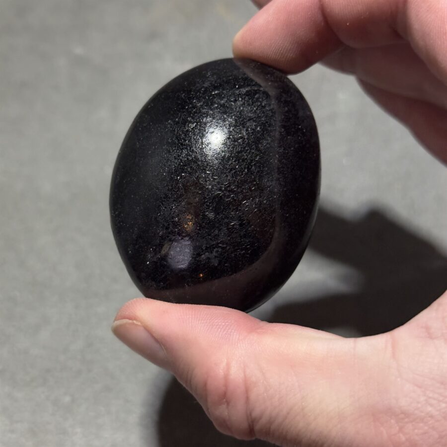 black tourmaline stone photographed on a neutral background, perfect for protective energies