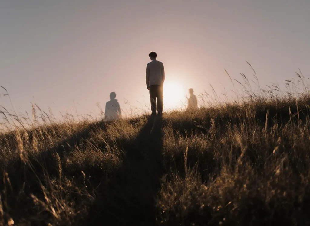 Silhuett av man i solnedgång på kulle.